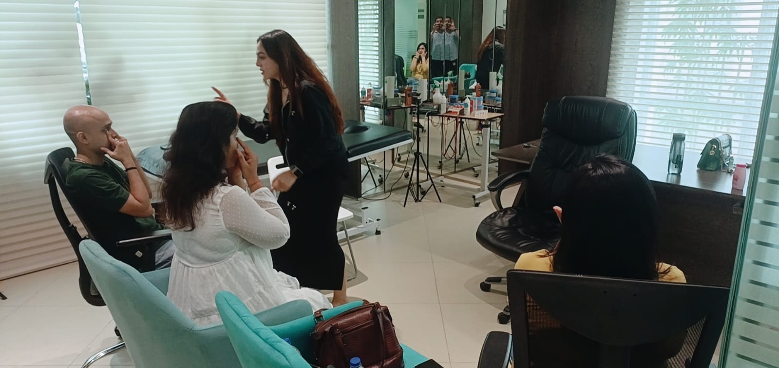 Vibha Jain stands and talks with a small group of seated people in a bright practice room.